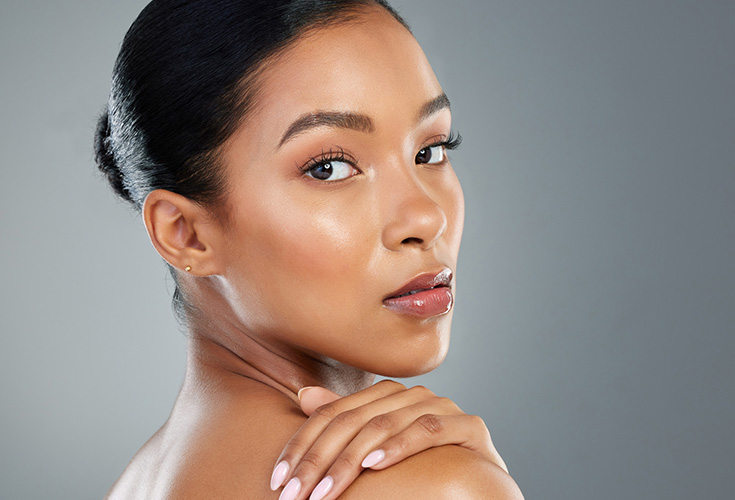 Portrait of a woman with sleek hair against a gray background